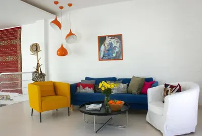 a living room with a blue couch and two chairs at La Buganvilla, bright and spacious apartment in the city centre in Chipiona