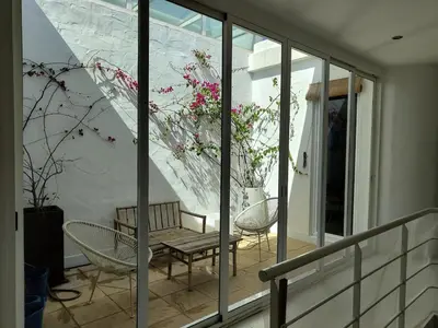 a balcony with a bench and a table and chairs at La Buganvilla, bright and spacious apartment in the city centre in Chipiona
