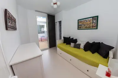 a room with a bed with a yellow and black pillows at La Buganvilla, bright and spacious apartment in the city centre in Chipiona