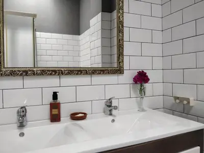 a white bathroom with a sink and a mirror at La Buganvilla, bright and spacious apartment in the city centre in Chipiona