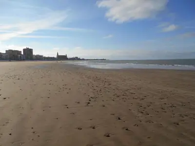 a beach with footprints in the sand and the ocean at Apartment Wohnung 'Caracola' mit Terrasse by Interhome in Chipiona