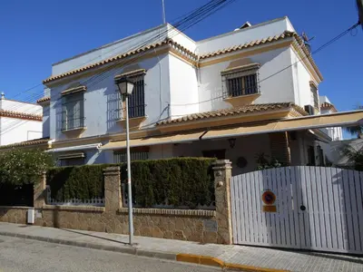 a white house with a fence in front of it at Apartment Wohnung Klimaanlage- Wifi- Terrasse- by Interhome in Chipiona