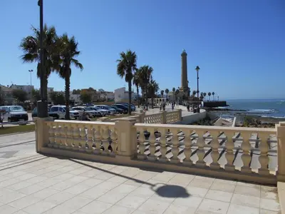 a white fence on a sidewalk near the ocean at Apartment Wohnung Klimaanlage- Wifi- Terrasse- by Interhome in Chipiona