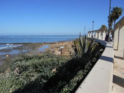 a beach next to a building and a sidewalk at Apartment Wohnung Klimaanlage- Wifi- Terrasse- by Interhome in Chipiona