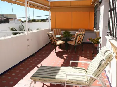 a patio with chairs and a table on a balcony at Apartment Wohnung Klimaanlage- Wifi- Terrasse- by Interhome in Chipiona