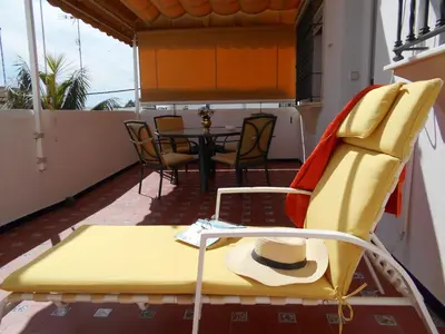 a yellow chair and a table on a balcony at Apartment Wohnung Klimaanlage- Wifi- Terrasse- by Interhome in Chipiona