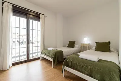a bedroom with two beds and a large window at Allo Apartments Catedral Centro 3 Habitaciones in Jerez de la Frontera