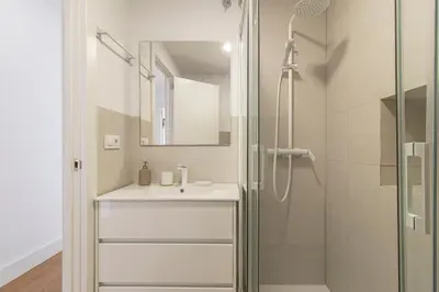 a bathroom with a white sink and a shower at Allo Apartments Catedral Centro 3 Habitaciones in Jerez de la Frontera