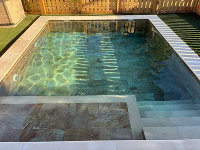 a swimming pool with water in a backyard at Finca La Arboleda in Chipiona