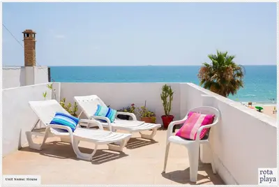 a group of chairs sitting on a balcony overlooking the ocean at Relaxing Seaside Getaway in the Heart of Rota in Rota