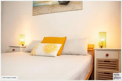 a bedroom with a white bed with two lamps at Relaxing Seaside Getaway in the Heart of Rota in Rota