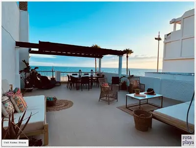 a patio with a table and chairs and the ocean at Relaxing Seaside Getaway in the Heart of Rota in Rota