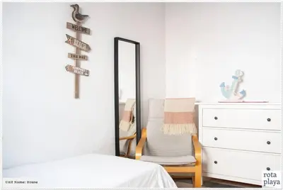 a mirror in a bedroom with a bed and a chair at Relaxing Seaside Getaway in the Heart of Rota in Rota