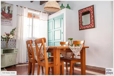 a dining room with a wooden table and chairs at Relaxing Seaside Getaway in the Heart of Rota in Rota