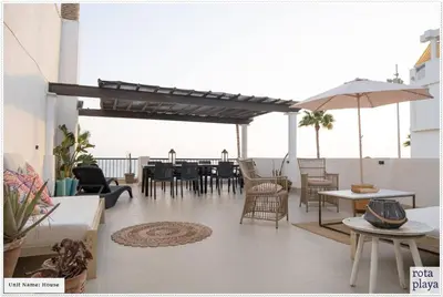 a patio with a table and chairs and an umbrella at Relaxing Seaside Getaway in the Heart of Rota in Rota