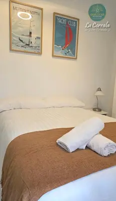a bedroom with a bed with two posters on the wall at Corrala Juan Grande 2 con garaje by Sanlúcar Housing in Sanlúcar de Barrameda