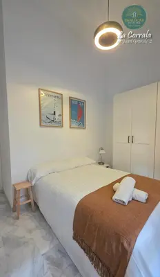 a bedroom with two beds and a light fixture at Corrala Juan Grande 2 con garaje by Sanlúcar Housing in Sanlúcar de Barrameda