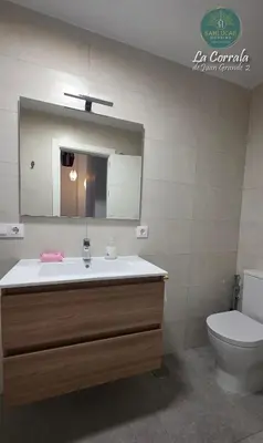 a bathroom with a sink and a toilet and a mirror at Corrala Juan Grande 2 con garaje by Sanlúcar Housing in Sanlúcar de Barrameda