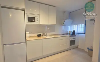 a white kitchen with a sink and a microwave at Corrala Juan Grande 2 con garaje by Sanlúcar Housing in Sanlúcar de Barrameda