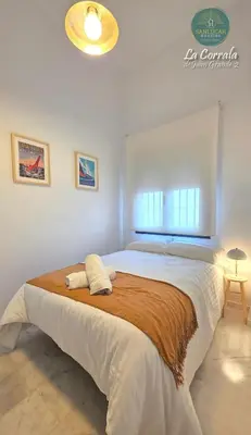 a bedroom with a large bed in a room at Corrala Juan Grande 2 con garaje by Sanlúcar Housing in Sanlúcar de Barrameda
