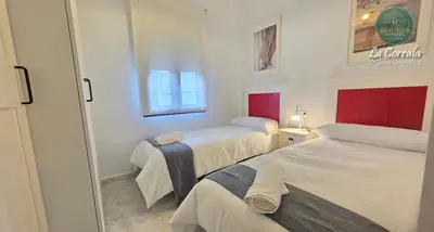 a small room with two beds and a mirror at Corrala Juan Grande 2 con garaje by Sanlúcar Housing in Sanlúcar de Barrameda