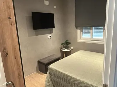 a bedroom with a bed and a tv on the wall at Villa Los Pinares in Poblado de Sancti Petri