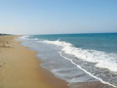 a beach with the ocean and the waves at Villa Los Pinares in Poblado de Sancti Petri