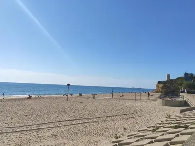 a beach with people and the ocean in the background at Villa Los Pinares in Poblado de Sancti Petri