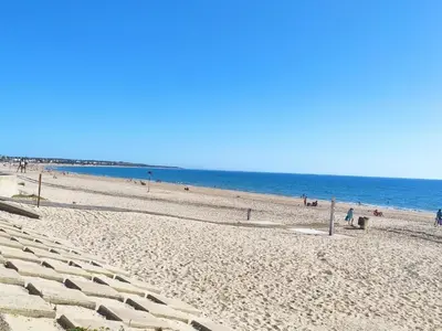 a beach with people and the ocean in the background at Villa Los Pinares in Poblado de Sancti Petri