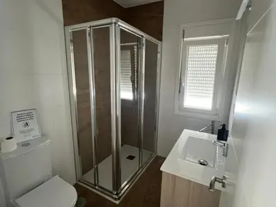 a bathroom with a shower and a toilet and a sink at Villa Los Pinares in Poblado de Sancti Petri