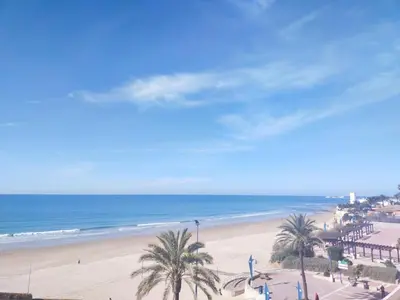 a view of a beach with palm trees and the ocean at Villa Los Pinares in Poblado de Sancti Petri