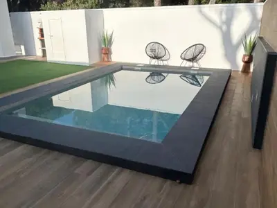 two chairs sitting next to a swimming pool at Villa Los Pinares in Poblado de Sancti Petri