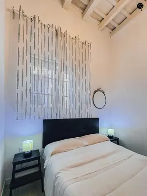 a bedroom with a bed and two tables with lamps at Los Callejones de la Pepa Grupo AC Gestion in Cádiz