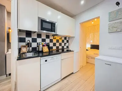 a kitchen with white cabinets and black and white tiles at Los Callejones de la Pepa Grupo AC Gestion in Cádiz