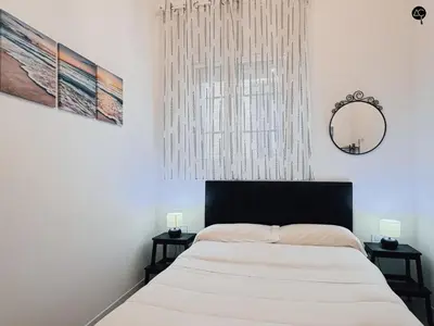 a bedroom with a bed with a mirror and two side tables at Los Callejones de la Pepa Grupo AC Gestion in Cádiz