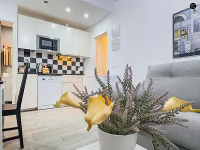 a living room with a couch and a vase with flowers at Los Callejones de la Pepa Grupo AC Gestion in Cádiz
