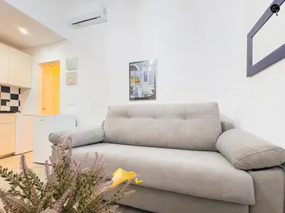 a gray couch in a living room with a christmas tree at Los Callejones de la Pepa Grupo AC Gestion in Cádiz
