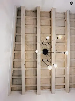a chandelier in front of a wooden wall at Los Callejones de la Pepa Grupo AC Gestion in Cádiz