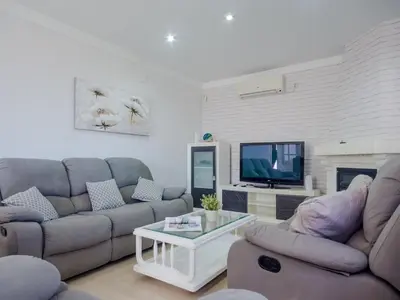 a living room with two couches and a tv at Villa Los Veleros 15119 in Chiclana de la Frontera