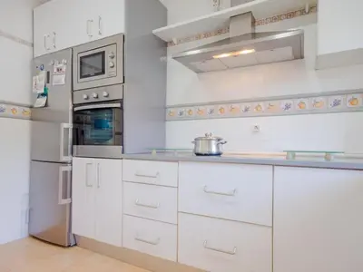 a kitchen with white cabinets and a refrigerator at Villa Los Veleros 15119 in Chiclana de la Frontera