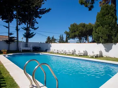 a swimming pool with chairs in a yard at Villa Los Veleros 15119 in Chiclana de la Frontera