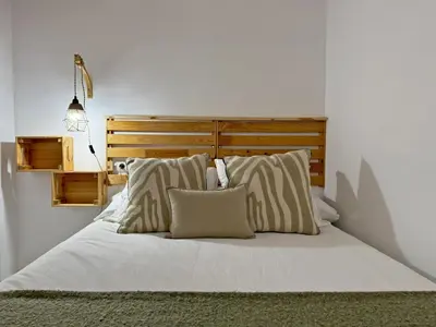 a bed with white sheets and pillows in a bedroom at Apartamento Castellanos - Ole Solutions in Jerez de la Frontera