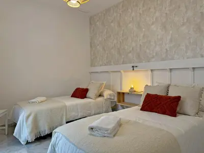 a room with two beds and a table with a lamp at Apartamento Castellanos - Ole Solutions in Jerez de la Frontera