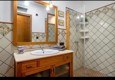 a bathroom with a sink and a mirror and a shower at Apartamento Playa Enamorados in El Puerto de Santa María