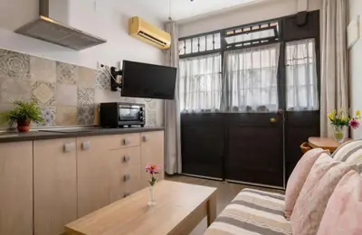 a living room with a kitchen and a black door at Apartamento Playa Enamorados in El Puerto de Santa María