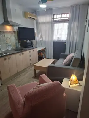 a hotel room with a bed and a living room at Apartamento Playa Enamorados in El Puerto de Santa María