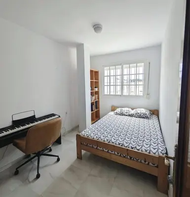a bedroom with a bed and a desk and a keyboard at Molly's Sunny Penthouse in Sanlúcar de Barrameda
