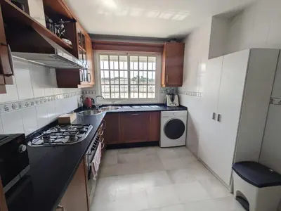 a small kitchen with a stove and a dishwasher at Molly's Sunny Penthouse in Sanlúcar de Barrameda