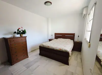 a bedroom with a bed and a dresser and window at Molly's Sunny Penthouse in Sanlúcar de Barrameda
