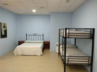 a bedroom with two bunk beds and a blue wall at Cádiz bahía in Cádiz